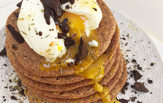Pancakes speziati di grano saraceno con pomodori, uovo in camicia e cioccolata fondente.